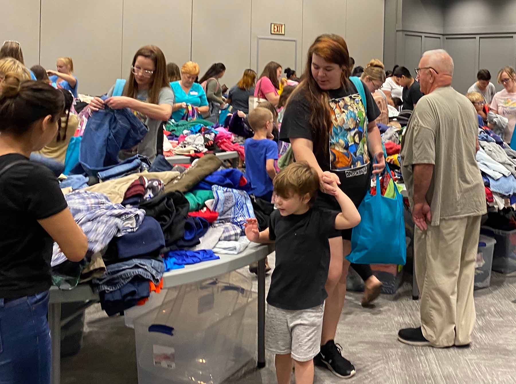 Children and parents looking through clothing.